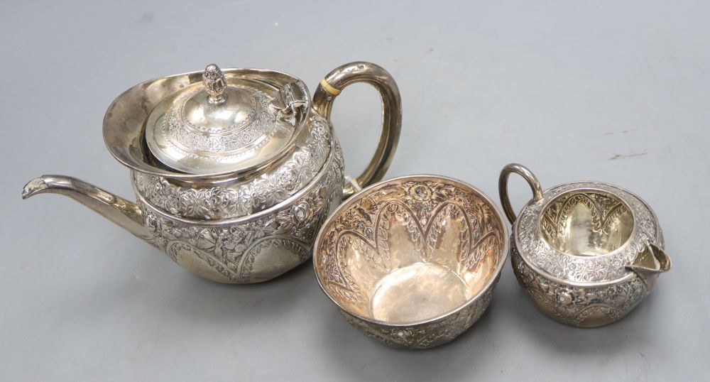 A late Victorian bachelors embossed silver three piece tea set, Mappin & Webb, Sheffield, 1895, gross 16 oz.